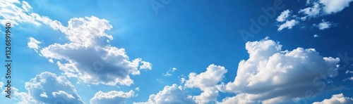 Panoramic white clouds drifting across vibrant blue sky on sunny day