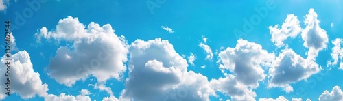 Bright sun shining through white fluffy clouds in blue sky