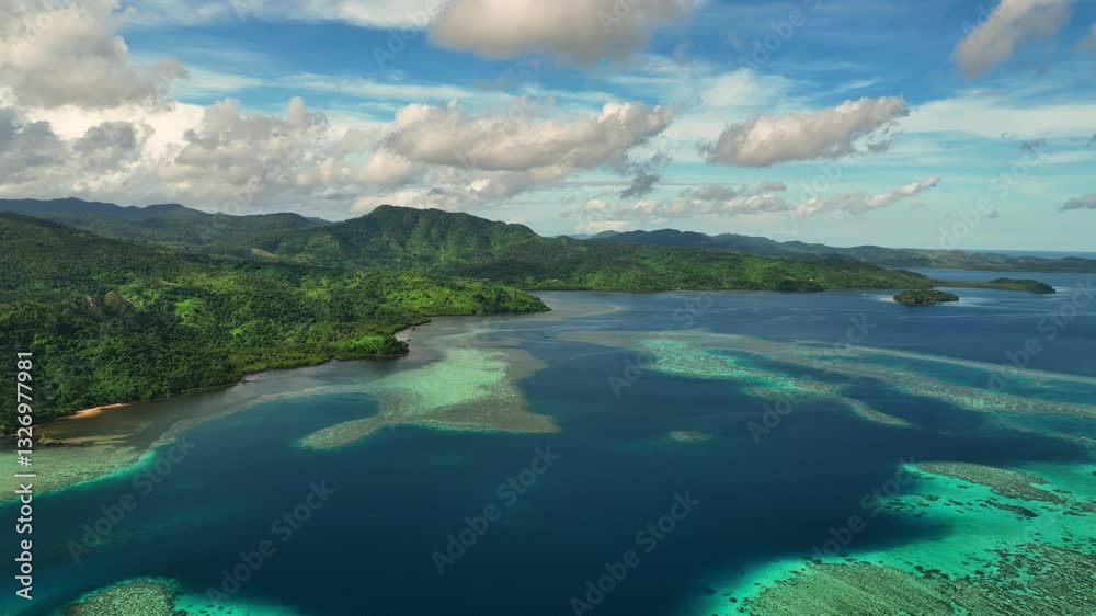 Aerial view of a beautiful tropical island with a serene reef and azure ocean under clouds, Nacomoto, Eastern, Fiji. Aerial view of a beautiful tropical island with a serene reef and azure ocean under clouds, Nacomoto, Eastern, Fiji.