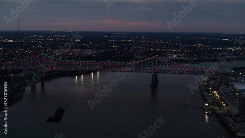 Aerial view of Crescent City Connection bridge over the Mississippi River at sunset with illuminated skyline, French Quarter, New Orleans, Louisiana, United States. photo