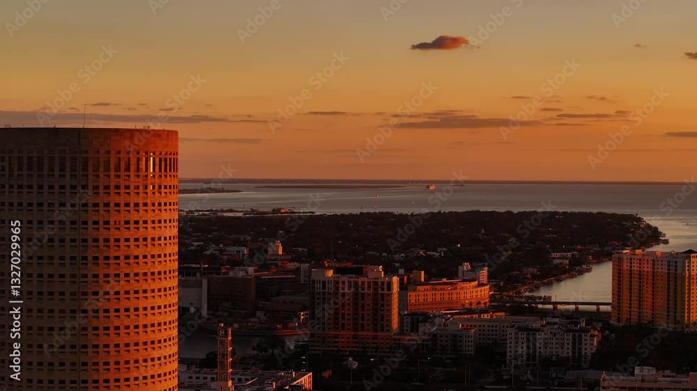 Tampa, United States - 01 February 2025: Aerial view of sunset skyline with Rivergate Tower and urban buildings reflecting on water, Downtown Tampa, Florida, United States.