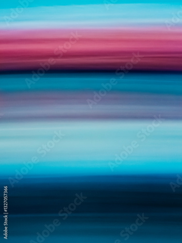 Streaks of color blend harmoniously in a tranquil horizon at sunset over a serene water landscape