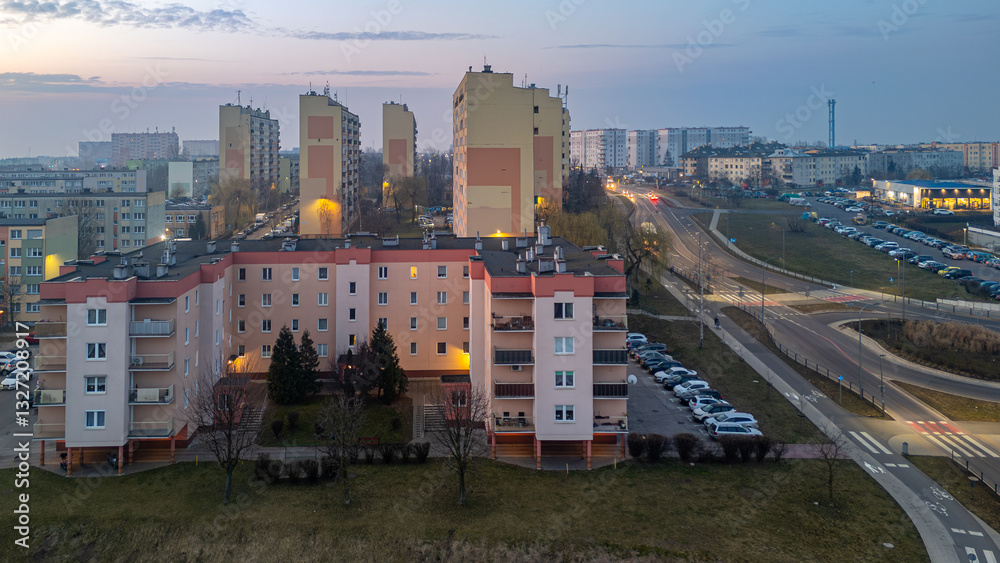 Obraz premium city ​​landscape in poland in the morning. aerial view of sunrise in the city of Kalisz. illuminated apartment blocks, skyscrapers and streets.