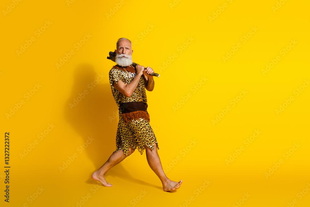 Naklejka premium Full length photo of funny funky barbarian guy dressed leopard fur holding axe walking blank space isolated yellow color background