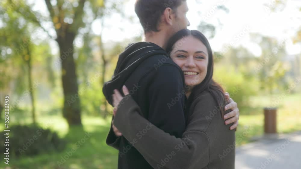 Couple Shares Happy Hug in Autumn Park, Surrounded by Fall Colors Couple Shares Happy Hug in Autumn Park, Surrounded by Fall Colors