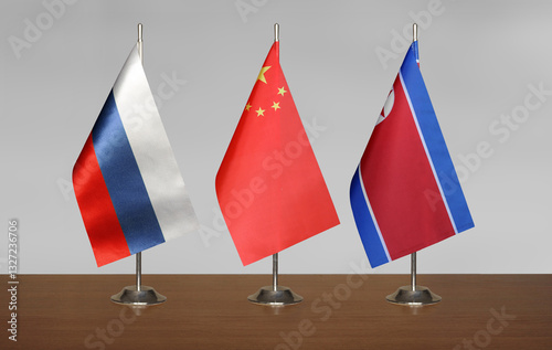 Flags China, Russia, North Korea on a gray blurred background
