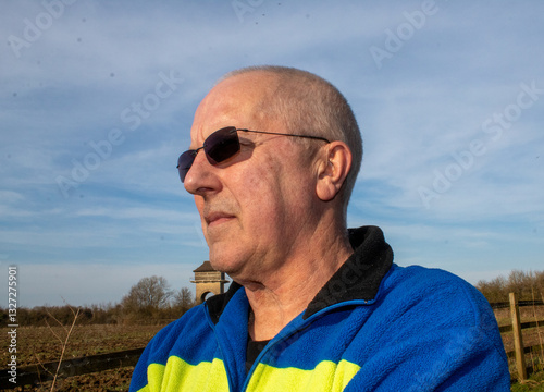 portrait of an elderly man looks into the distance wearing sunglasses