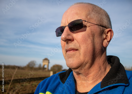 portrait of an elderly man looks into the distance wearing sunglasses