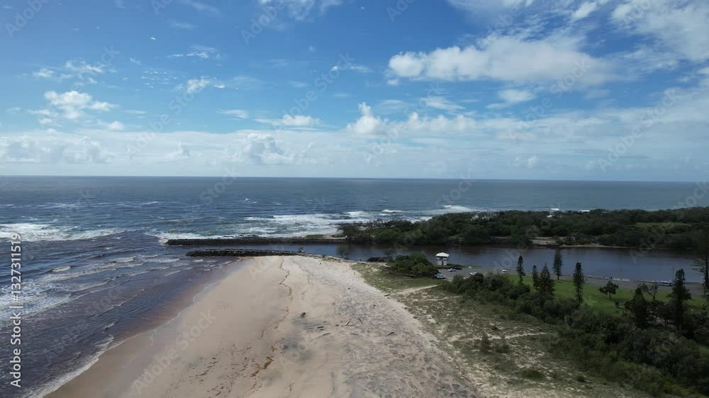 Aerial views of muddy waters from Cudgen Creek after Cyclone Alfred flowing in to the sea at Kingscliff headland seawall along the east coast of New South Wales, Australia Aerial views of muddy waters from Cudgen Creek after Cyclone Alfred flowing in to the sea at Kingscliff headland seawall along the east coast of New South Wales, Australia