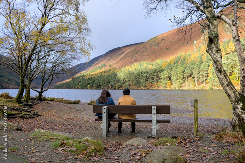 Two people looking at the lake in Glendalough (Valley of the Two Lakes) in the Wicklow Mountains; Derrybawn, County Wicklow, Ireland photo