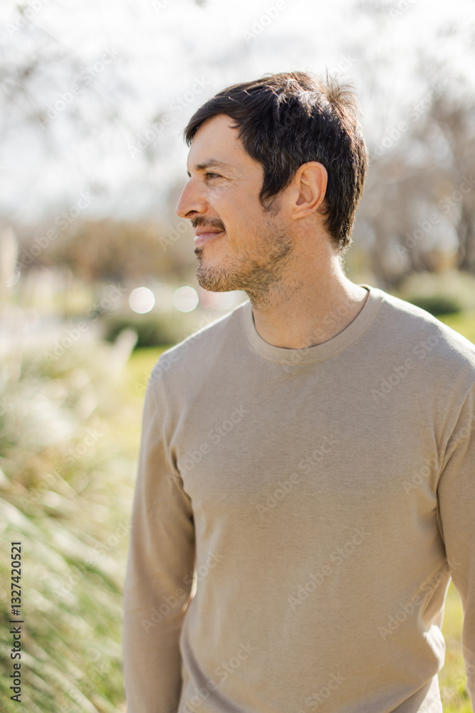A middle-aged Caucasian man gazes into the distance with a calm expression, enjoying nature and fresh air. Soft sunlight enhances tranquil atmosphere. Vertical, blurred background, warm serene mood. A middle-aged Caucasian man gazes into the distance with a calm expression, enjoying nature and fresh air. Soft sunlight enhances tranquil atmosphere. Vertical, blurred background, warm serene mood.
