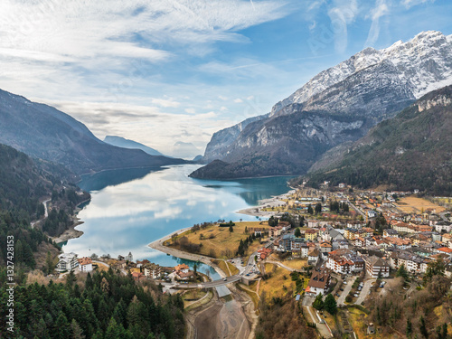 Aerial drone view of Lake Molveno, beautiful lake in Italy. Lake in dolomites from drone in winter. Lake Molveno in Italy. Sailboat, yacht on crystal clear lake in the Brenta Dolomites