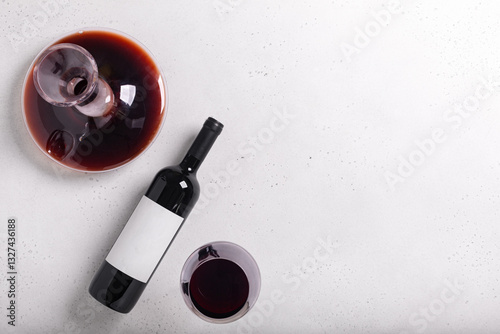 Decanter, glass and bottle with red wine on white. Flat lay