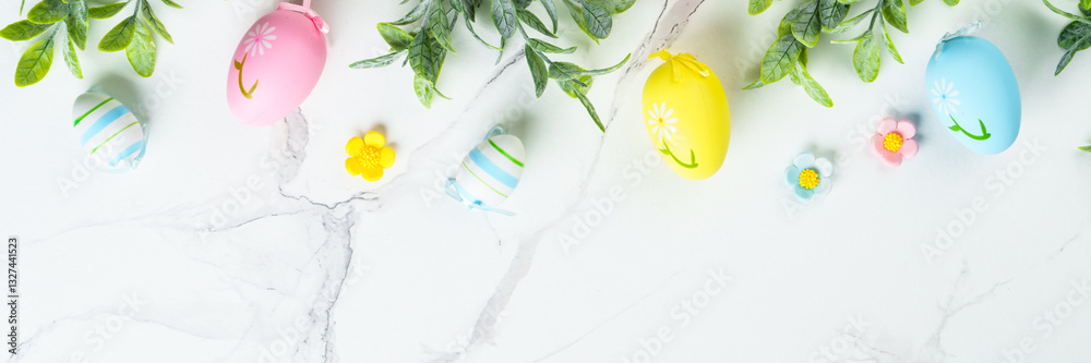 Easter composition with colored eggs and green plants on white background.