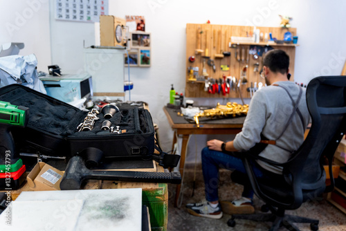 Fotografi Luthier repairing wind instruments in his workshop