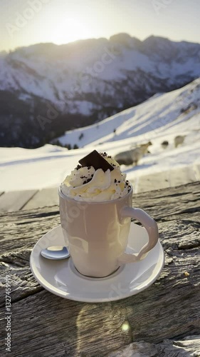 Chocolate Drink with Whipped Cream and Yak and Mountain in the Background in Italian Dolomites. Hot Beverage in a Cup with Winter Scene.