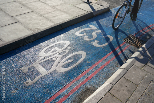 Obraz na płótnie Sun shines on bike symbol painted to cyclist road in a city w salonie