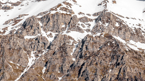 Obraz na płótnie Aerial view of rocks on a mountain partly covered by snow. Ideal for textures, backgrounds and patterns. w salonie