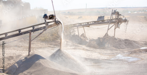 Vibrating screen stone crusher in operation. Crushing stones in a quarry for processing minerals, cement, limestone. Heavy and mobile equipment in a quarry for processing stone into building material.
