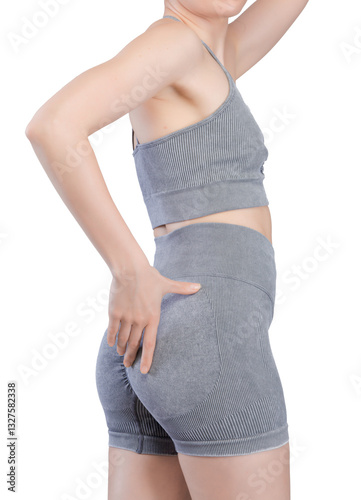 Studio shot of a fit woman's lower body from the back, showcasing her toned buttocks and legs. She is wearing a grey ribbed seamless sports bra and high-waisted shorts. The fabric is a textured knit.