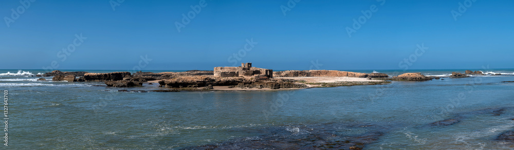Coastal landscape featuring ruins on the shoreline of Essaouira, Morocco in bright sunlight Coastal landscape featuring ruins on the shoreline of Essaouira, Morocco in bright sunlight