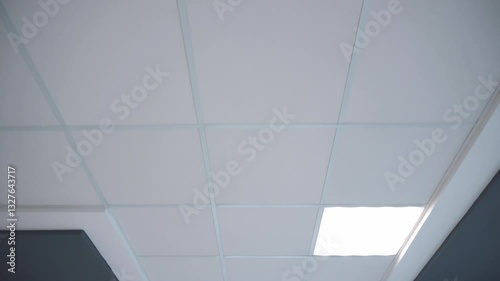 Square lamps on a white office ceiling. Interior design in the office. A fluorescent lamp on a modern suspended ceiling.
