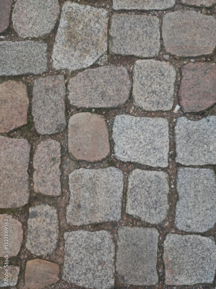 Old cobblestone pavement with a mix of gray and brown stones, creating a rustic and historic atmosphere. The worn texture and irregular shapes add character, making it perfect for backgrounds, archite Old cobblestone pavement with a mix of gray and brown stones, creating a rustic and historic atmosphere. The worn texture and irregular shapes add character, making it perfect for backgrounds, archite
