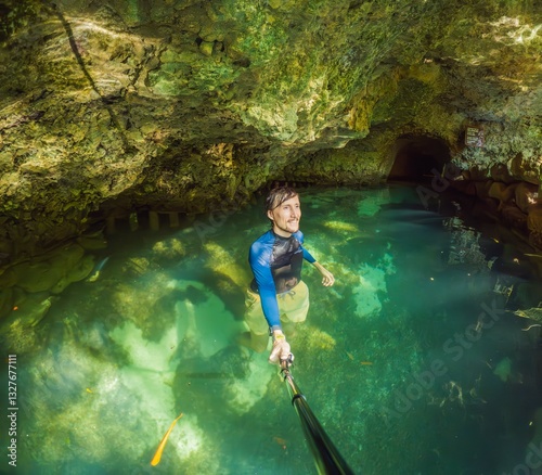 Man tourist in the water of a Mexican cenote surrounded by natural beauty. Adventure travel, eco-tourism, and exploration concept in a tropical paradise