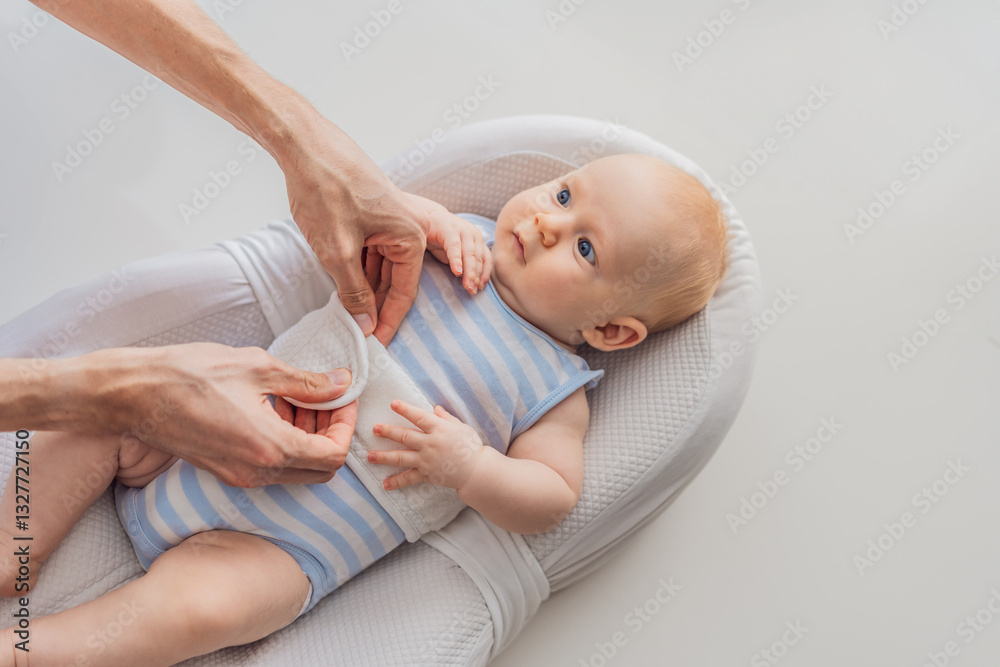 Adorable 3-month-old baby lying safely in a cozy infant cocoon secured with a special safety belt. Comfortable and protective design for newborn care. Parenting, safety, and baby comfort concept