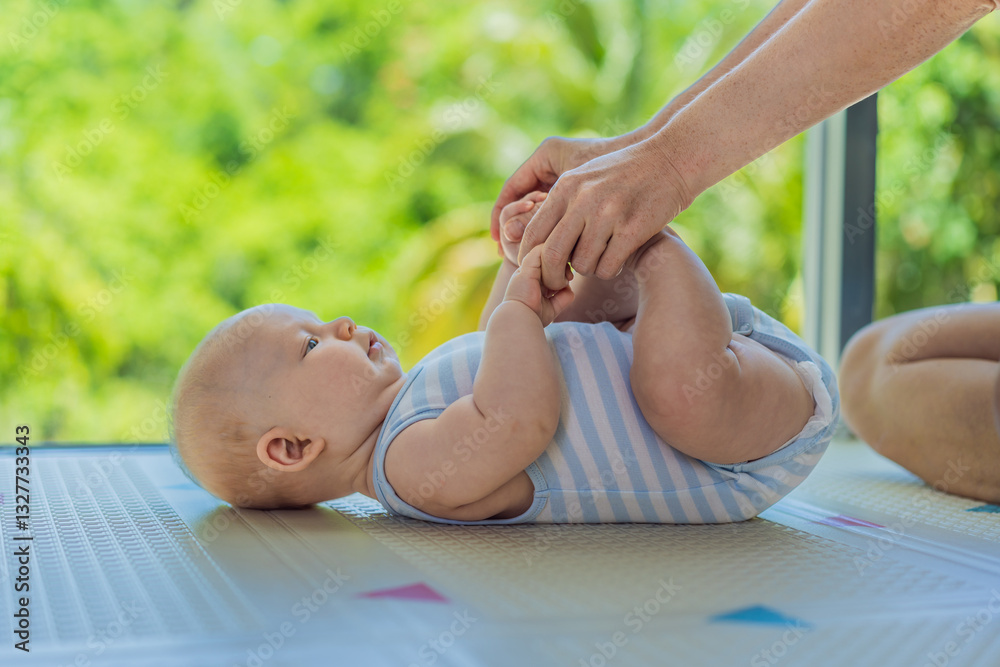 A mother practices baby gymnastics with her 3-month-old on a soft children's play mat. A joyful and nurturing moment focused on bonding, development, and care. Early childhood, fitness, and parenting