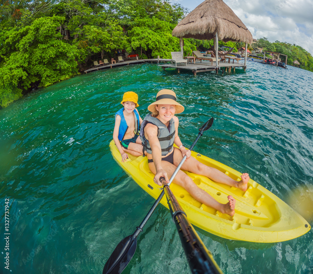 Mother and son tourists kayaking together on the crystal-clear turquoise waters of Lake Bacalar, Mexico. Family bonding, outdoor adventure, and tropical travel concept in a serene natural setting