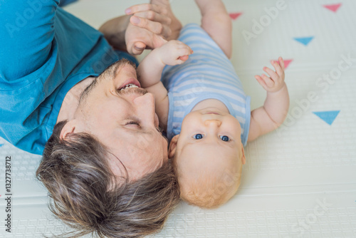Obraz na płótnie A loving father lies next to his 3-month-old baby, safely secured in a cozy infant cocoon with a special safety belt. Heartwarming family bonding moment. Parenthood, love, and baby care concept w salonie