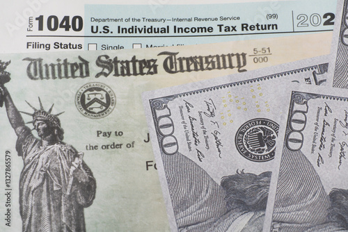 Prop US currency and treasury department check and top of 1040 tax form