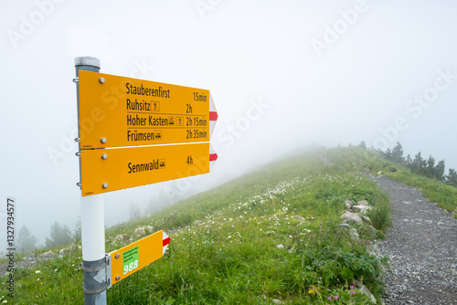 Switzerland Travel - typical trail Signpost in the Swiss Alps in the Appenzell region with limited views do to fog and cloud cover on Mountain top photo