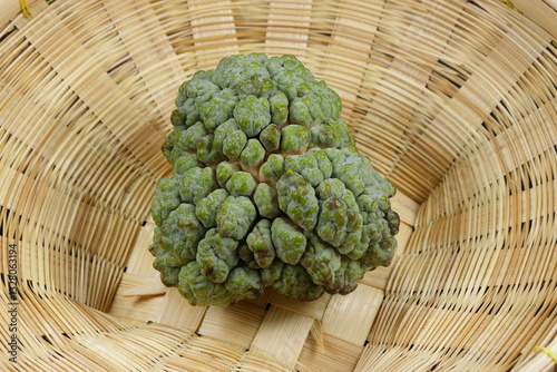 Fresh and organic custard apple on the wooden basket. Famous tropical fruit in Asia. 