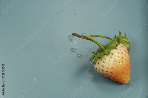 strawberry with water splash isolated on blue background.