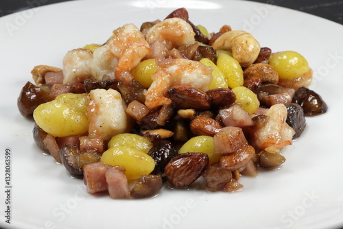 Traditional Chinese ancient menu in restaurant. Famous stirred and fried ginkgo, chestnut, ham sausage, cashew nut and peeled shrimp serving on the plate.