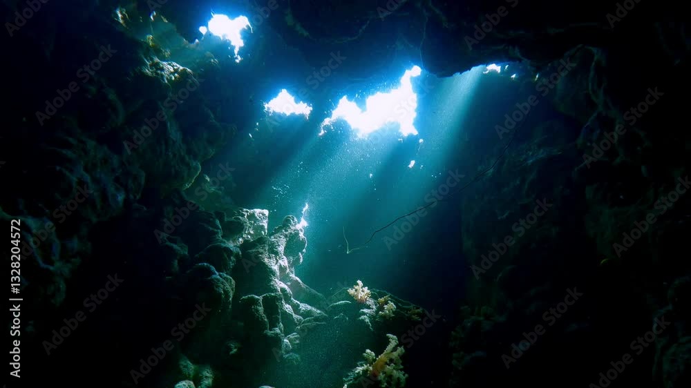 Beams of mystical light Illuminating the tranquil aquatic realm in enchanting underwater cave, Slow motion, adventure and marine caves exploration concept, diving in a coral caves