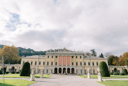 Park with statues in front of the ancient Villa Olmo with empty banners on the facade. Lake Como, Italy