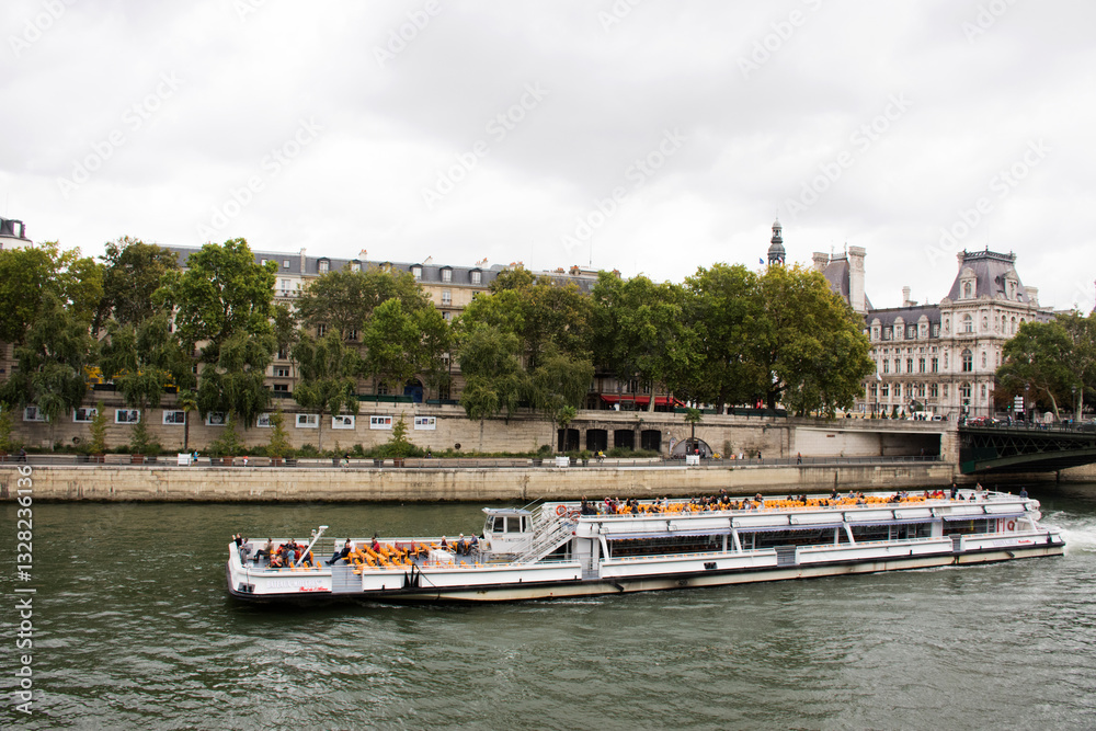 Obraz premium River Cruises sailing bring travelers passengers tour and looking old town Paris city at riverside of Seine river