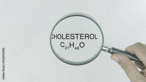 Cholesterol text highlighted by a magnifying glass in a hand on a white background, symbolizing focus on lipid levels, heart health, and blood circulation