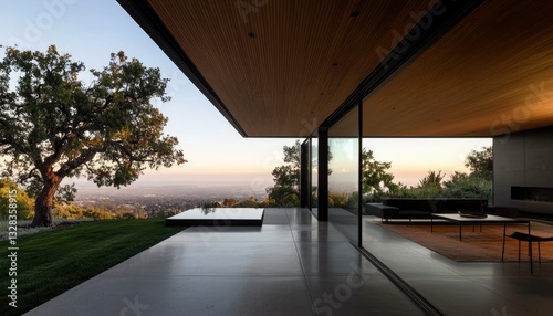 Modern home's expansive patio overlooks a serene valley sunset, showcasing seamless indoor-outdoor living
