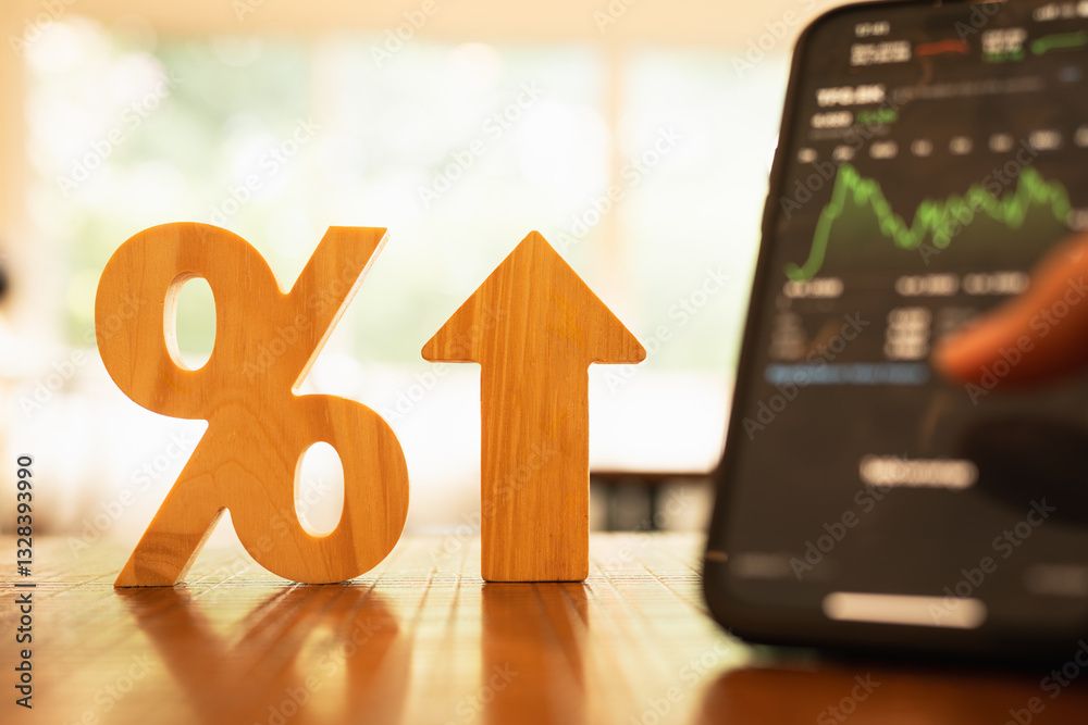 Φωτογραφία Model of a wooden Percentage sign on the table, together with a businessman 's hand looking at a stock chart