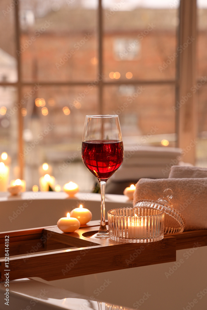 Φωτογραφία Stand with glass of wine, towels and burning candles in bathroom, closeup