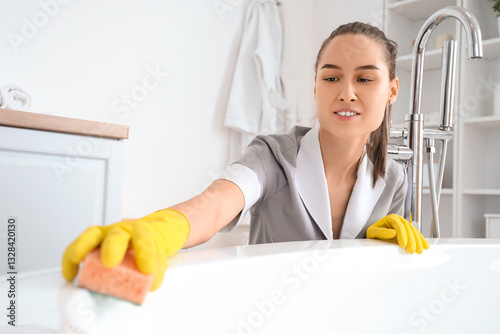 Young chambermaid cleaning ...