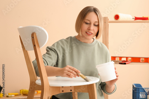 Young woman painting wooden...