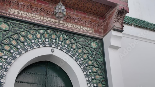 Detailed establishing pan of an ornate Moroccan doorway at the Grand Mosque in Tangier, intricate tilework to tower