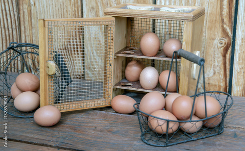 chicken eggs in a decorative box anf metal baskets on a table in front of a w...