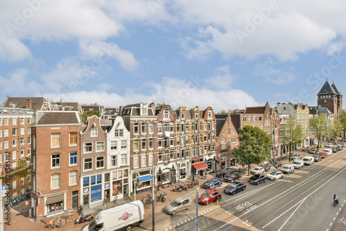 Photography Charming streets lined with historic buildings, cafes, and trees create a picturesque cityscape in Amsterdam