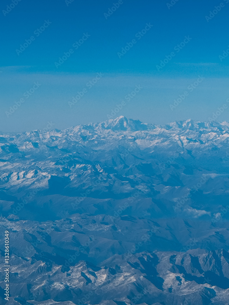 The sky is blue and the mountains are covered in snow. The mountains are very tall and the snow is very white The sky is blue and the mountains are covered in snow. The mountains are very tall and the snow is very white